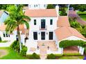 Stunning aerial view of a white Spanish-style home showcasing the red tile roof and manicured landscaping at 1234 W Ivanhoe Blvd, Orlando, FL 32804