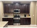 The kitchen is equipped with stainless steel appliances, granite countertops, and dark wood cabinetry at 1446 Vivaldi Pl, Longwood, FL 32779