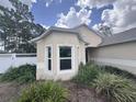 Charming exterior view showcasing the home's architectural details and a white fenced in yard with lush landscaping at 2921 Blackburn Ave, Deltona, FL 32738