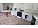 Functional kitchen with white cabinets, range, and breakfast bar with ceramic tile flooring at 860 S Grove St, Eustis, FL 32726