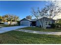 Gray house with a two-car garage and a well-manicured lawn at 1083 Sunshine Sw Way, Winter Haven, FL 33880