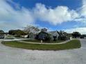 House exterior showcasing a gray color, landscaping, and a curved driveway at 1083 Sunshine Sw Way, Winter Haven, FL 33880