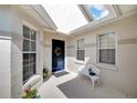 Front entry with blue door, white bench, and potted plants at 2178 Sunstone Dr, Lakeland, FL 33813