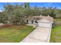 Single story house with a spacious yard, featuring a white garage and a blue front door at 4201 Shadow Wood Dr, Winter Haven, FL 33880