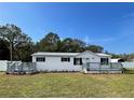 Newly remodeled single-wide home with gray deck and fenced yard at 7612 Glen Meadow Dr, Lakeland, FL 33810