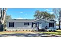 Gray mobile home with black shutters and landscaping at 9619 Moore Rd, Lakeland, FL 33809