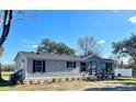 Landscaped manufactured home with gray siding and black accents at 9619 Moore Rd, Lakeland, FL 33809