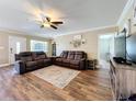 This living room boasts hardwood floors, a ceiling fan and comfortable couches at 1025 E Georgia St, Bartow, FL 33830