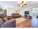 Cozy living room featuring a ceiling fan, hardwood floors and a large flat-screen TV at 1025 E Georgia St, Bartow, FL 33830