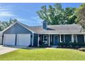 Charming single story home featuring an attached two-car garage, neat landscaping, and a welcoming covered front porch at 121 Belmont Dr, Winter Haven, FL 33884