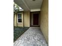 Front entry with brick walkway and a burgundy door at 2062 Katie Ct, Winter Haven, FL 33884