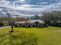 Ranch style home with metal roof and lush green lawn at 3703 White Oak Ct, Lake Wales, FL 33898