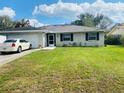 Well-maintained white brick house with an attached garage, lush green lawn, and a neatly manicured landscape at 419 Broward Ter, Winter Haven, FL 33884