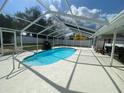 Enclosed pool area with a rock waterfall feature surrounded by a concrete deck, ideal for relaxing and entertaining at 419 Broward Ter, Winter Haven, FL 33884