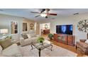 Comfortable living room with hardwood flooring, ceiling fan, and open layout to dining area at 7929 Chase Rd, Lakeland, FL 33810