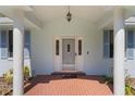 Covered front porch with brick flooring and decorative columns at 1131 Country Oaks Blvd, Lake Wales, FL 33898
