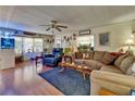 Comfortable living room featuring a ceiling fan, hardwood floors, and abundant natural light from the windows at 1575 Longbow Dr, Lakeland, FL 33810