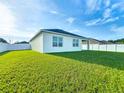 Expansive backyard with lush green grass and a white fence offers plenty of privacy at 1835 Jackson Oaks Dr, Bartow, FL 33830