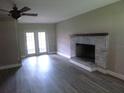 Bright living room with gray laminate floors and brick fireplace with hearth at 1835 Mount Pisgah Rd, Fort Meade, FL 33841