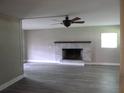 Living room featuring gray laminate floors and fireplace with brick surround at 1835 Mount Pisgah Rd, Fort Meade, FL 33841