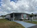 Inviting single story home with a covered driveway, adorned with vibrant flowers and landscaping at 2055 S Floral Ave # 69, Bartow, FL 33830