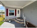 Cozy front porch with brick-lined steps and red shutters, creating a welcoming entrance at 2055 S Floral Ave # 69, Bartow, FL 33830