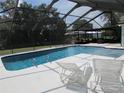 Relaxing screened-in pool area with lounge chairs, ideal for enjoying the outdoors and soaking up the sunshine at 2742 Pine Acres Dr, Lake Wales, FL 33898
