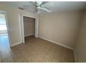 An open bedroom featuring a ceiling fan, tile floors, and a spacious closet at 340 W Stanford St, Bartow, FL 33830