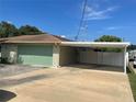 Two car garage with additional parking space under a covered carport at 4805 Oak Acres Dr, Lake Wales, FL 33898