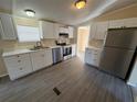 Well-lit kitchen showcases stainless steel refrigerator and appliances and white cabinetry at 5138 Rock Dove Trl, Lakeland, FL 33810