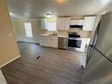 Updated kitchen featuring stainless steel appliances, white cabinets, and wood-look flooring at 5138 Rock Dove Trl, Lakeland, FL 33810