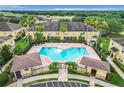 Aerial view of a community pool surrounded by lush landscaping and multiple lounge chairs at 519 Sandstone St, Lakeland, FL 33809