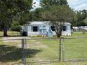 Charming home with fenced yard, well-maintained lawn, light blue painted porch, and matching shutters at 5217 Turtle Dove Trl, Lakeland, FL 33810
