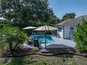 Inviting backyard with a sparkling pool, outdoor seating, and lush landscaping for relaxation and entertainment at 5427 Orange Valley Dr, Lakeland, FL 33813