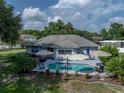 Aerial view of a private backyard featuring a refreshing pool, patio with seating, and beautifully landscaped surroundings at 5427 Orange Valley Dr, Lakeland, FL 33813