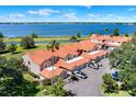 Aerial view of waterfront townhomes featuring tile roofs, private garages, and lush greenery along a picturesque lakefront at 804 Magnolia Pl # 804, Winter Haven, FL 33884