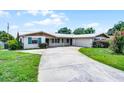 Inviting single-story home with a long driveway leading to an attached garage at 900 Howard Nw Ter, Winter Haven, FL 33881
