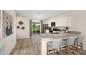 Modern kitchen features granite countertops, stainless steel appliances, and breakfast bar seating at 2242 Majestic Span Ave, Eagle Lake, FL 33839