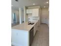 Kitchen island with stainless steel dishwasher, sink, and quartz countertops at 6107 Sw 115Th Street Rd, Ocala, FL 34476