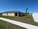 View of the back of the house from sidewalk with sliding glass door to covered porch at 2203 Majestic Span Ave, Eagle Lake, FL 33839