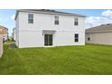Spacious backyard featuring a well-maintained lawn and a sliding glass door entrance at 1813 Grassmere St, Haines City, FL 33844