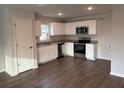 Modern kitchen with white cabinets, granite countertops, and stainless steel appliances at 2322 Sw 146Th Loop, Ocala, FL 34473