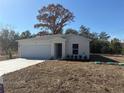 Newly constructed home with a white exterior and a spacious yard at 28 Magnolia Dr, Ocklawaha, FL 32179