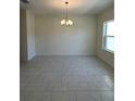 This dining room boasts modern tile floors and a contemporary chandelier above at 5530 Sw 103Rd St Rd, Ocala, FL 34476