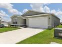 Side view of a single-story home with a two-car garage and a well-manicured lawn at 4323 Periwinkle Pl, Lake Hamilton, FL 33851
