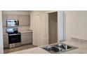 Modern kitchen featuring stainless steel appliances and gray cabinets at 1807 Don Pl, Poinciana, FL 34759