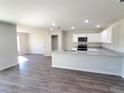 Open-concept kitchen featuring granite countertops, stainless steel appliances, and modern gray flooring at 2491 Nw 23Rd Ave, Ocala, FL 34475