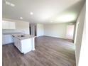 Open-concept living room area with gray wood-look floors that transition seamlessly to the kitchen at 2491 Nw 23Rd Ave, Ocala, FL 34475