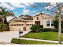 Two-story house with a three-car garage, landscaping, and a mailbox at 30120 Hackney Loop, Mount Dora, FL 32757