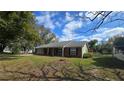 Traditional brick home with a well-maintained lawn, dark shutters, and a covered front porch at 1223 Lawrence Ave, Deltona, FL 32725